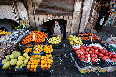 מוכר פירות בשוק בדמשק. בערים הגדולות הפעילות נמשכה כמעט כרגיל (צילום: AP) (צילום: AP)