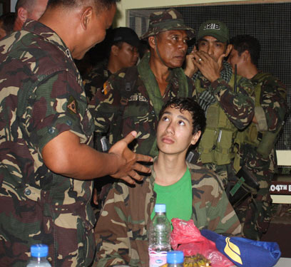 הנער קווין עם חיילים בפיליפינים אחרי הבריחה (צילום: AP) (צילום: AP)