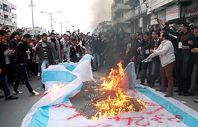 שריפת דגל ישראל בעיר חומס (צילום: AFP / SANA) (צילום: AFP / SANA)