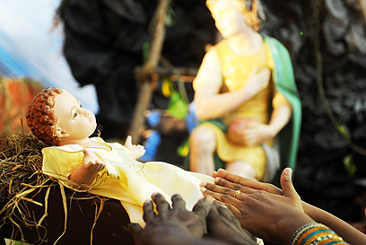 סרי לנקה. מאמינים מושיטים ידיים לבובת ישו התינוק (צילום: AFP) (צילום: AFP)