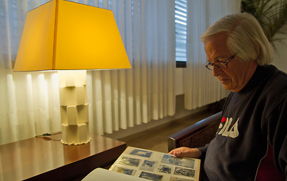 רני סוסקין עם אלבום תמונות שצילם סבו עם הרוליפלקס (צילום: יניב ברמן) (צילום: יניב ברמן)