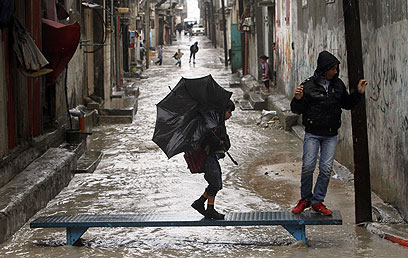 מחכים בגשם, ברחובות הרצועה (צילום: AFP) (צילום: AFP)