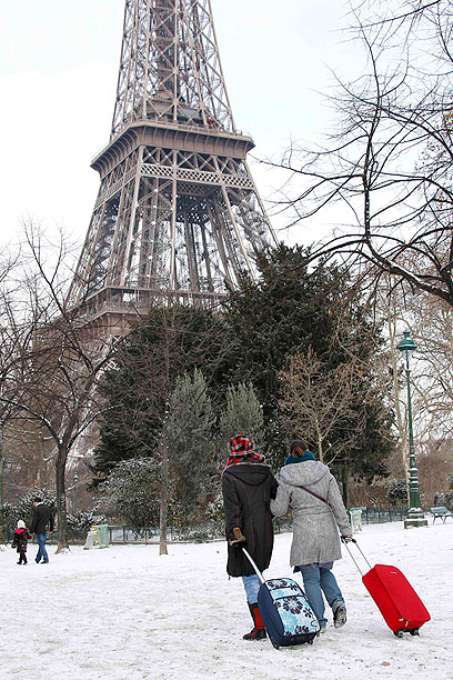 גוררים את המזוודות ליד מגדל אייפל בפריז, צרפת (צילום: רויטרס) (צילום: רויטרס)