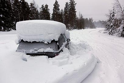 המכונית קבורה מתחת לשלג בשבדיה (צילום: EPA) (צילום: EPA)