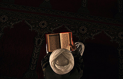 בנאט"ו התנצלו. מתפלל אפגני קורא מן הקוראן בקאבול (צילום: AFP) (צילום: AFP)