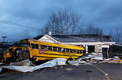 אוטובוס תלמידים שהועף לעבר בית (צילום: AP) (צילום: AP)