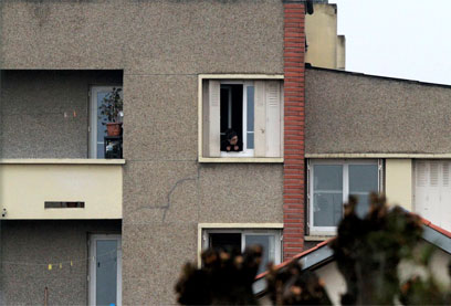 שכניו של מראח צופים בפעילות השוטרים מחוץ לבניין (צילום: רויטרס) (צילום: רויטרס)