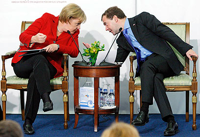 פוטין טען שהוא צריך לעסוק רק במדיניות חוץ. מדבדב ומרקל (צילום: AP) (צילום: AP)