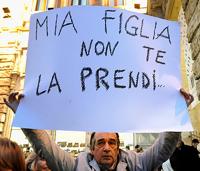 מפגין מניף שלט: "לא אתן לך את בתי" (צילום: AFP) (צילום: AFP)