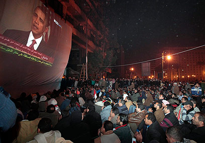 מפגינים בקהיר צופים באובמה בזמן המחאה נגד משטר מובארק (צילום: AP) (צילום: AP)