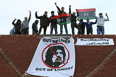 פולשים מקרב המורדים על גג אחוזתו של קדאפי הבן  (צילום: AP) (צילום: AP)