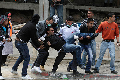 מפנים פצוע פלסטיני בקלנדיה (צילום: רויטרס) (צילום: רויטרס)