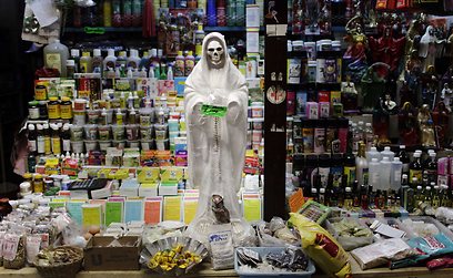פסלון "המוות הקדוש" בדוכן בשוק. לראשונה זה שנים שמתגלה קורבן אדם (AP) (AP)