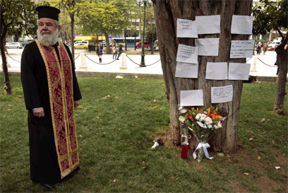 כומר אורתודוכסי מבקר במקום ההתאבדות (צילום: רויטרס) (צילום: רויטרס)