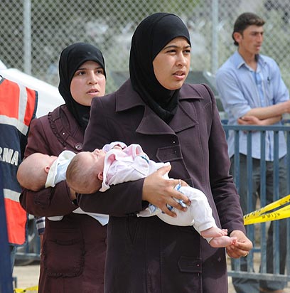 אמהות ותינוקות חוצים את הגבול לטורקיה (צילום: EPA) (צילום: EPA)