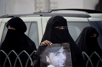 מפגינה אוחזת בתמונת מפגין שנהרג לפני שבועיים (צילום: AFP) (צילום: AFP)