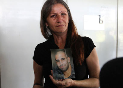 אמו של אמסיס עם תמונתו בבית המשפט (צילום: עופר עמרם) (צילום: עופר עמרם)