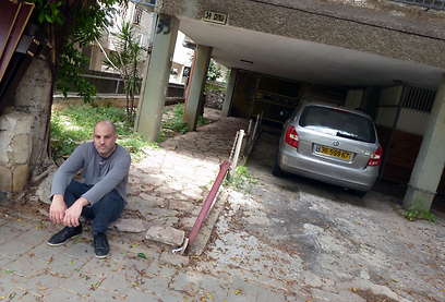 ערן קולירין על רקע בניין ילדותו בתל אביב (צילום: אמיר בוגן) (צילום: אמיר בוגן)