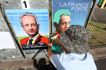 קריקטורות של סרקוזי (מימין) והולנד ברחוב (צילום: AFP) (צילום: AFP)
