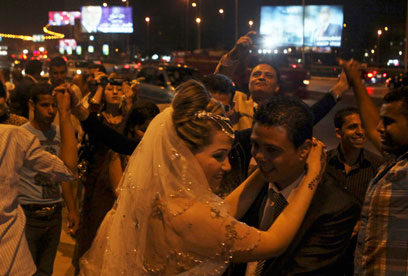 חתן וכלה על רקע שלטי הפרסומת של מועמדים בקהיר (צילום: רויטרס) (צילום: רויטרס)