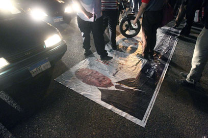 מפגינים דורכים על כרזה של שפיק (צילום: AFP) (צילום: AFP)