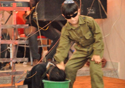 ילד מחופש לחייל צה"ל "מטביע" אסיר פלסטיני במסיבת הסיום ()
