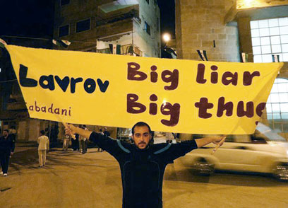 מפגין נגד לברוב בדמשק. "שקרן גדול, בריון גדול" (צילום: AP) (צילום: AP)