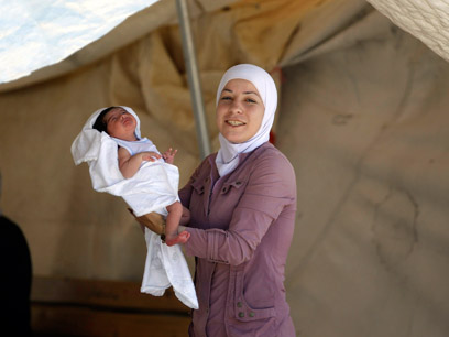 פליטה סורית ותינוקה במחנה פליטים בטורקיה (צילום: רויטרס) (צילום: רויטרס)