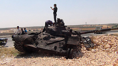 מורדים ליד טנקים שנפגעו באידליב (צילום: רויטרס) (צילום: רויטרס)