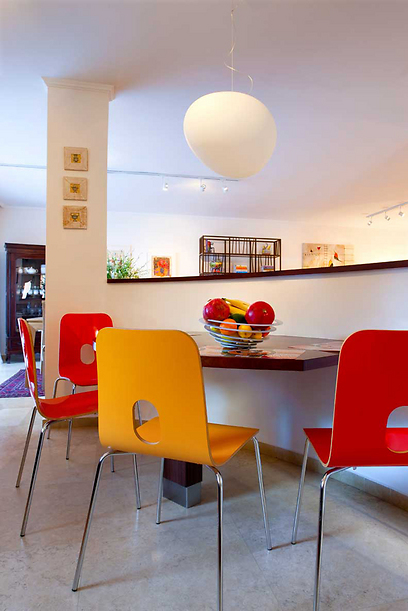 המטבח לא שופץ אלא נקנו לו אביזרים חדשים כמו כיסאות צבעוניים בגווני אדום וכתום ונתלתה מנורה מעל שולחן אוכל (צילום: עדי גלעד) (צילום: עדי גלעד)