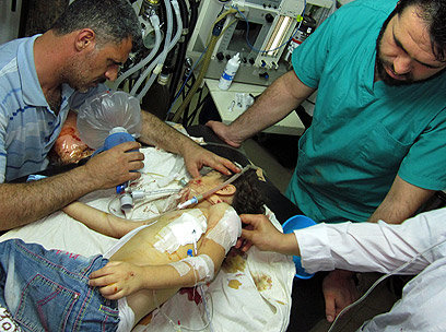 ילד פצוע מטופל ליד חומס (צילום: AFP PHOTO / HO / SHAAM NEWS NETWORK) (צילום: AFP PHOTO / HO / SHAAM NEWS NETWORK)