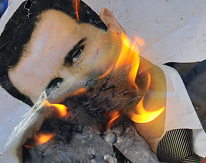מעלים באש את תמונתו של אסד ליד חלב (צילום: AFP) (צילום: AFP)
