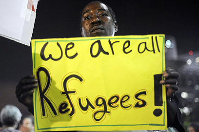 "כולנו פליטים". אחד הזרים שהשתתפו בהפגנה (צילום: AFP) (צילום: AFP)