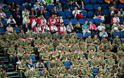 וככה מנסים להעלים את הבושה. חיילים בריטים צופים באולימפיאדה (צילום: MCT) (צילום: MCT)