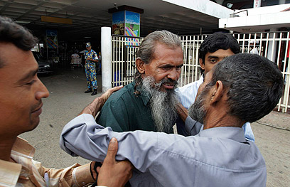 כל הכפר חיכה לקבל את פניו. סרקאר מתקבל בשדה התעופה ע"י אחיו (צילום: AP) (צילום: AP)