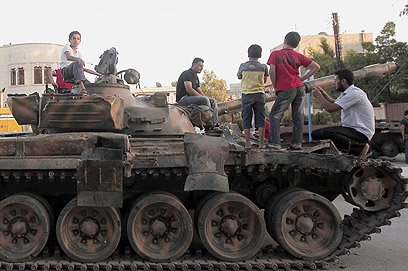 ילדים על טנק של צבא אסד בחלב (צילום: AFP) (צילום: AFP)