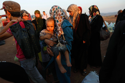 בורחים על נפשם. פליטים סורים בדרך לטורקיה (צילום: רויטרס) (צילום: רויטרס)