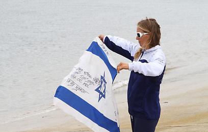 אדלמן, עם הדגל הישראלי, מחכה לקורזיץ בחוף (צילום: אורן אהרוני) (צילום: אורן אהרוני)