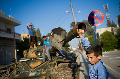 ילדים משחקים על טנק נטוש בעזאז, לפני שהופצצה (צילום: AFP) (צילום: AFP)