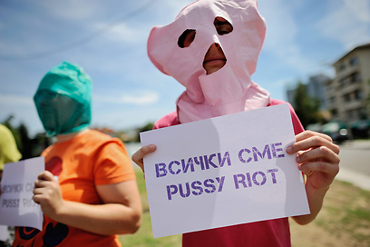 מפגין עם שלט "כולנו פוסי ריוט" מול שגרירות רוסיה בסופיה, בולגריה (צילום: EPA) (צילום: EPA)