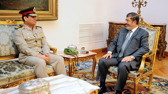 מורסי והגנרל עבד אל-פתאח א-סיסי ב-2012. שנה אחר כך א-סיסי הדיח אותו בהפיכה צבאית (צילום: AFP) (צילום: AFP)