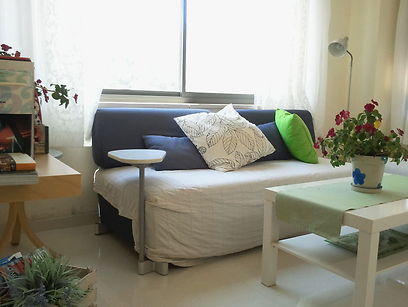 חדר המגורים: כרית לבנה עם הדפס עלים מתחברת בקלות לשאר הדירה הלבנה והפרחונית (צילום: ענת רייס) (צילום: ענת רייס)
