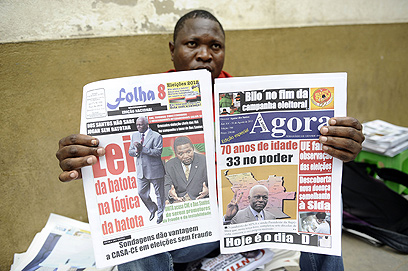 "תמיכה מתמשכת בנשיא ובמפלגת השלטון". מוכר עיתונים בלואנדה (צילום: AFP) (צילום: AFP)