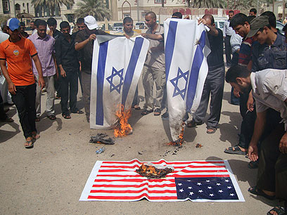Protesters burn flags in Iraq (Photo: AFP)