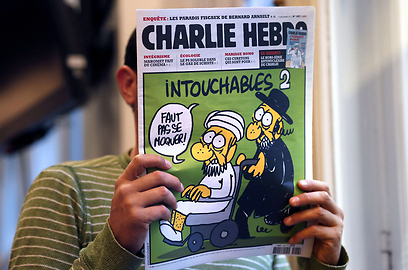 יהודי דתי גורר מוסלמי בכיסא גלגלים על שער השבועון הצרפתי (צילום: AFP ) (צילום: AFP )