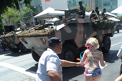 פמיניסטית מ-Femen מתפרצת למצעד צבאי בברזיל (צילום: EPA) (צילום: EPA)
