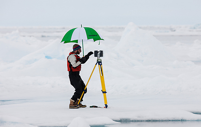פעיל גרינפיס מודד את הצטמקות הקרחונים (צילום: אלכס יאלופ, גרינפיס) (צילום: אלכס יאלופ, גרינפיס)