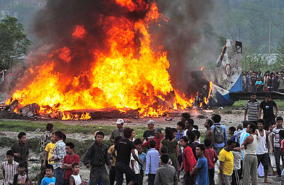 המטוס עולה באש סמוך לשדה התעופה (צילום: AP) (צילום: AP)