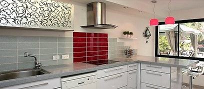 המטבח. קלאפה עם חזית מאויירת, שיש אפור וחיפויי קיר המשלב אריחים אדומים (צילום: שחר אהרוני) (צילום: שחר אהרוני)