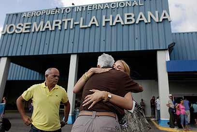 תושבת שחזרה מארה"ב בשדה התעופה הבינ"ל של קובה (צילום: AP) (צילום: AP)